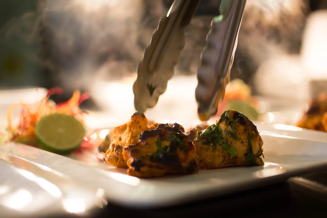 A chef finishing a plated course, a multi-course menu inspired by India’s regions